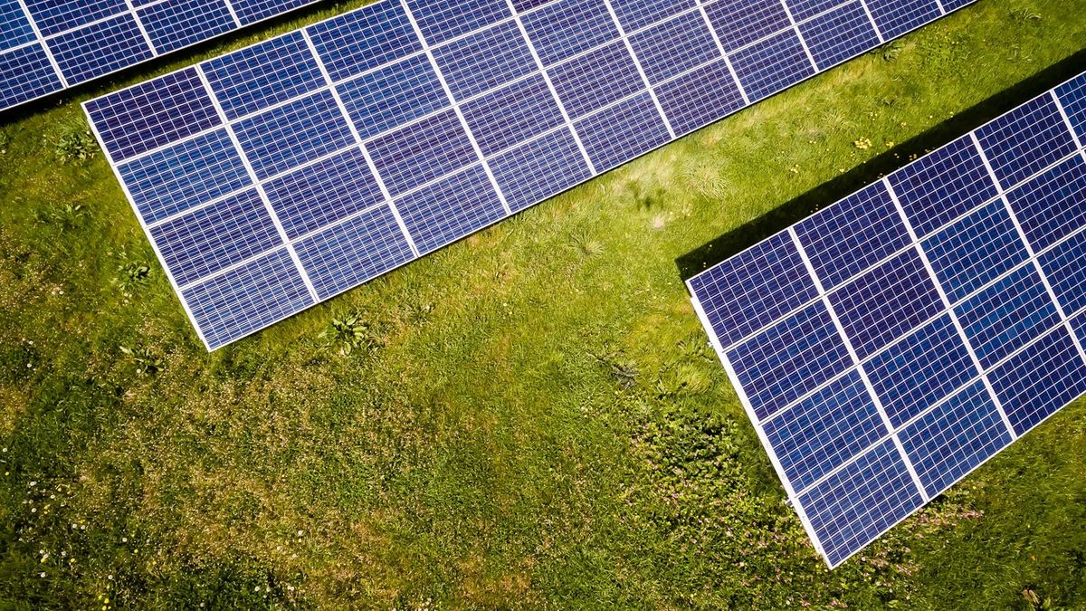Aerial view of solar panels in a green field