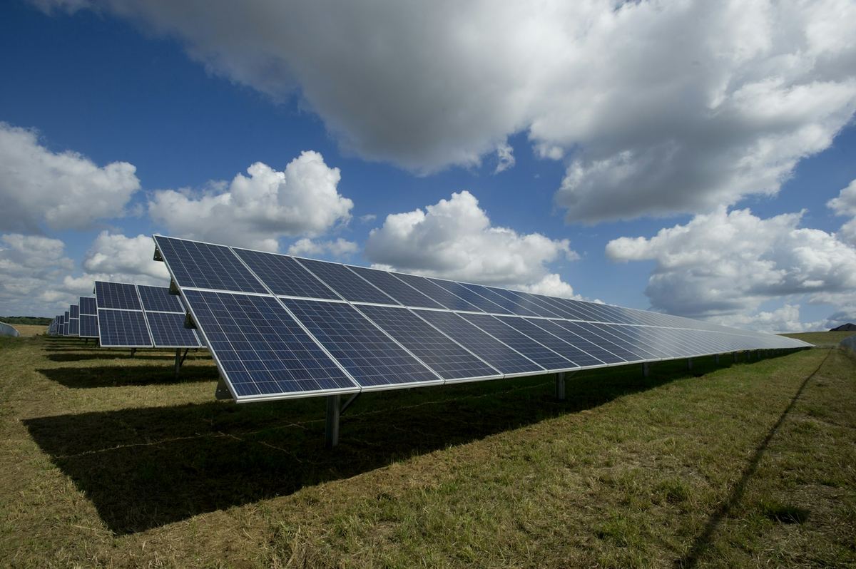 Rows of solar panels under a bright blue sky